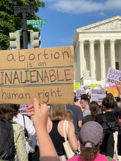 Protesters marching in Washington, DC, and carrying signs saying Abortion Is An Unalienable Human Right.