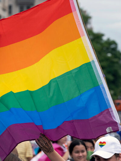 A rainbow flag with the U.S. capitol in the background.