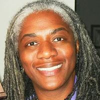 a closeup image of a Black woman with long hair that is past the shoulders