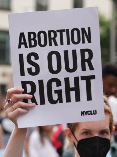 A demonstrator holding a sign that says Abortion is Our Right.