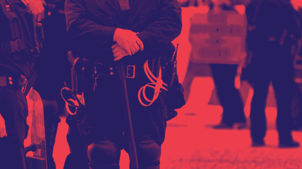 red and dark blue image, police officers standing by with a protester in the background
