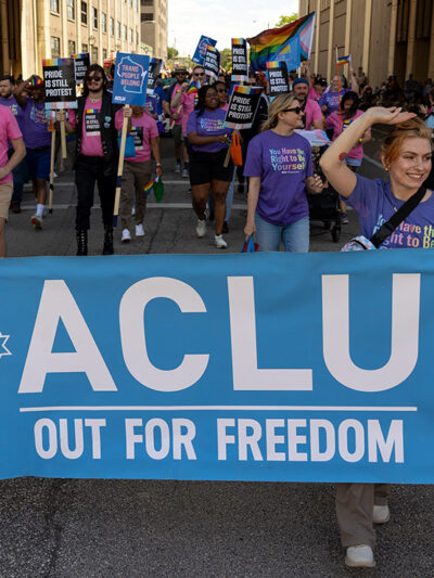 Two demonstrators holding a sign that says "ACLU Out For Freedom."