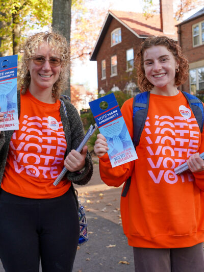 Voter volunteers holding voting pamphlets.
