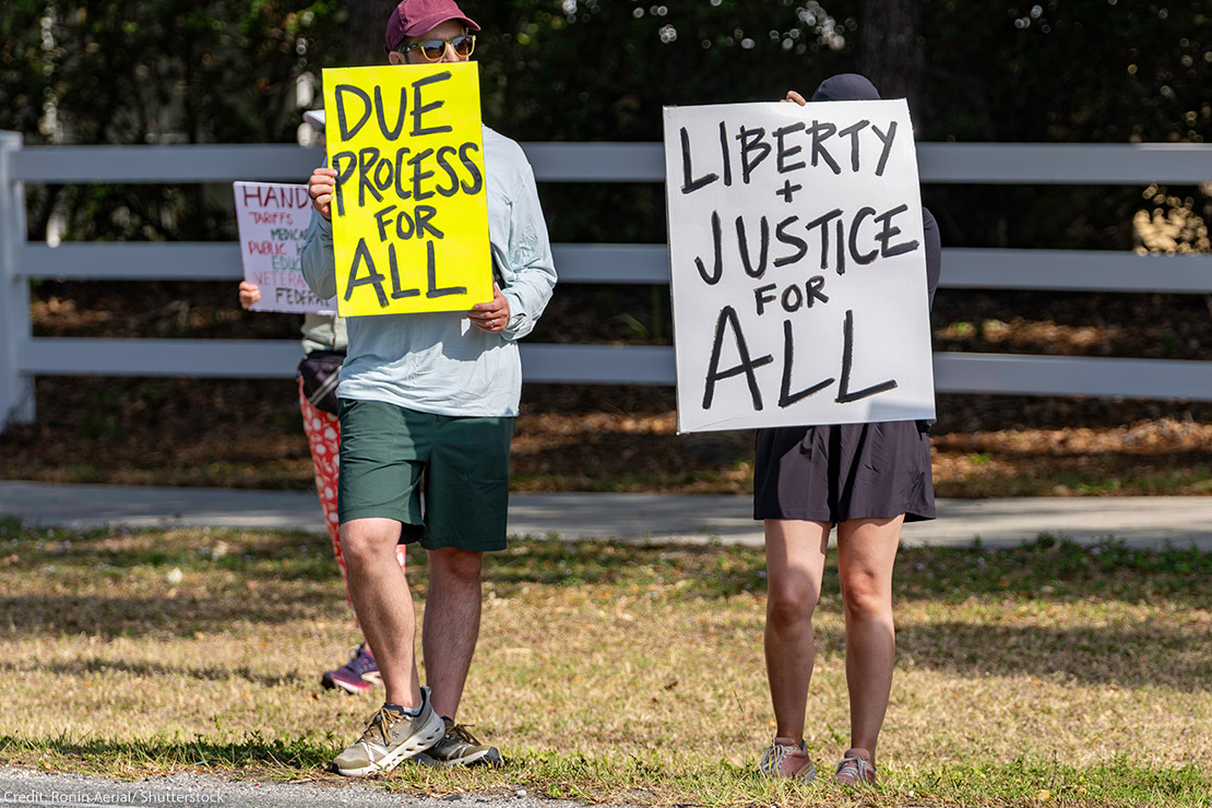 A protest with individuals holding signs in favor of due process.