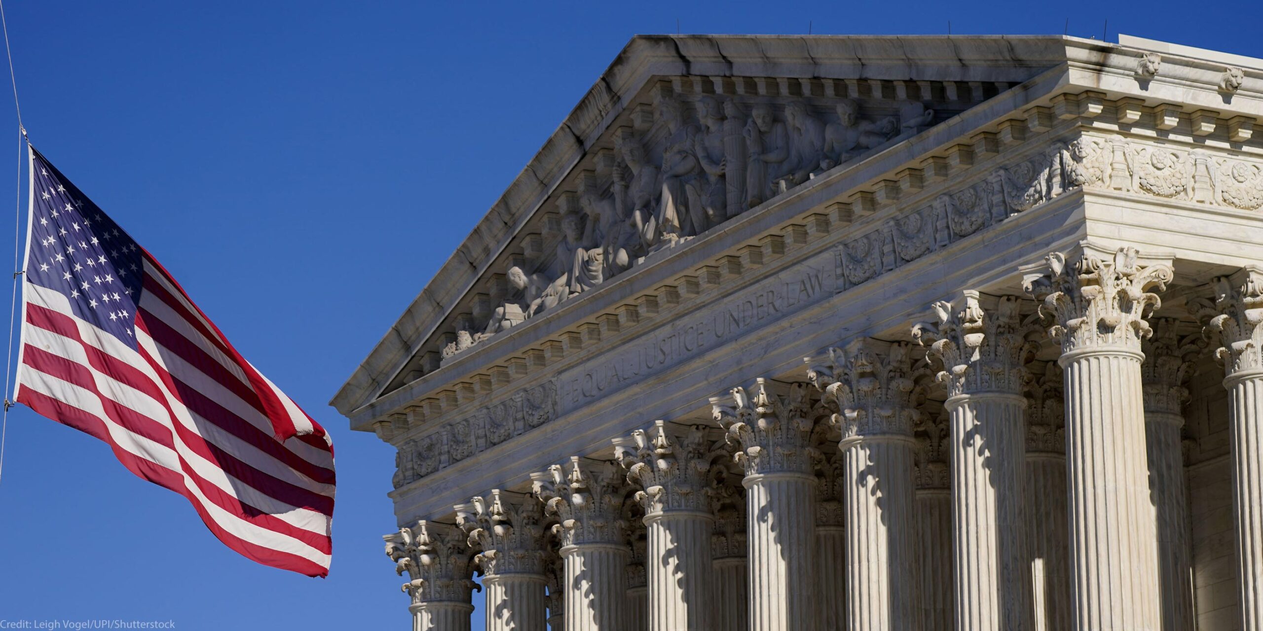 A half-lowered US flag waves in front of the US Supreme Court.