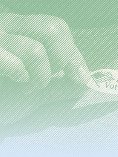 A hand placing a "I Voted" sticker on shirt