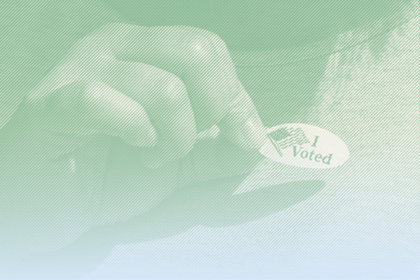 A hand placing a "I Voted" sticker on shirt