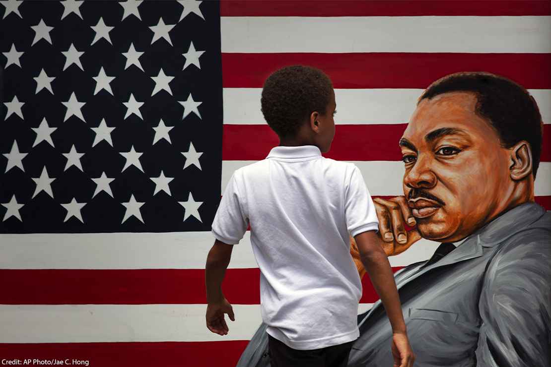 Child admiring a mural of Dr. Martin Luther King