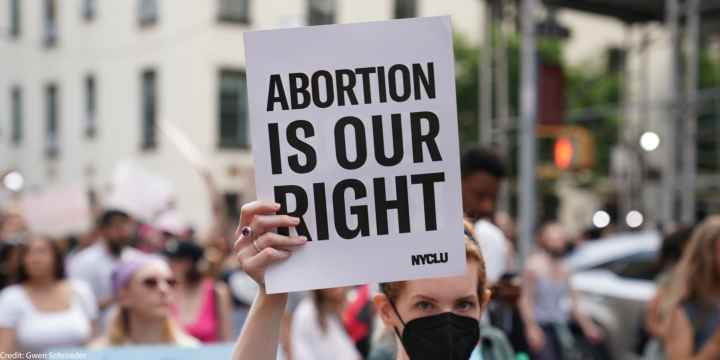 A demonstrator holding a sign that says Abortion is Our Right.