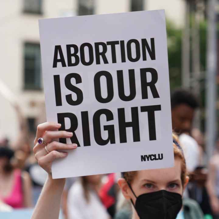 A demonstrator holding a sign that says Abortion is Our Right.