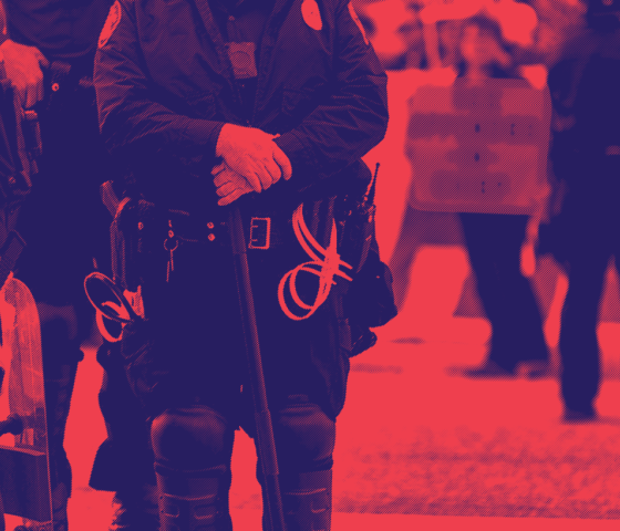 red and dark blue image, police officers standing by with a protester in the background